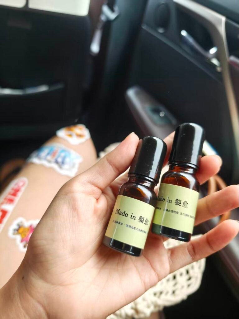 Hand holding two essential oil rollers for a neck and shoulder ritual
